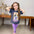 Smiling girl in a navy blue Mickey Mouse T-shirt with a floral graphic, paired with purple capri leggings featuring a matching Mickey print.