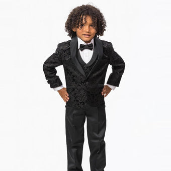 Young boy wearing a black formal tuxedo with a bow tie, patterned jacket, white shirt, and matching black pants.