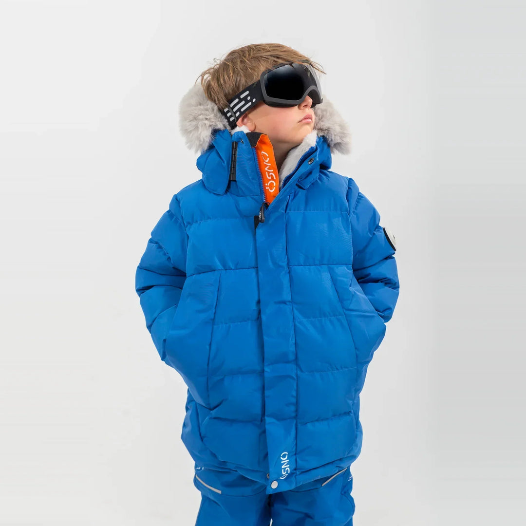 Boy wearing blue ÖSNO ski jacket with faux fur hood trim and orange inner lining.