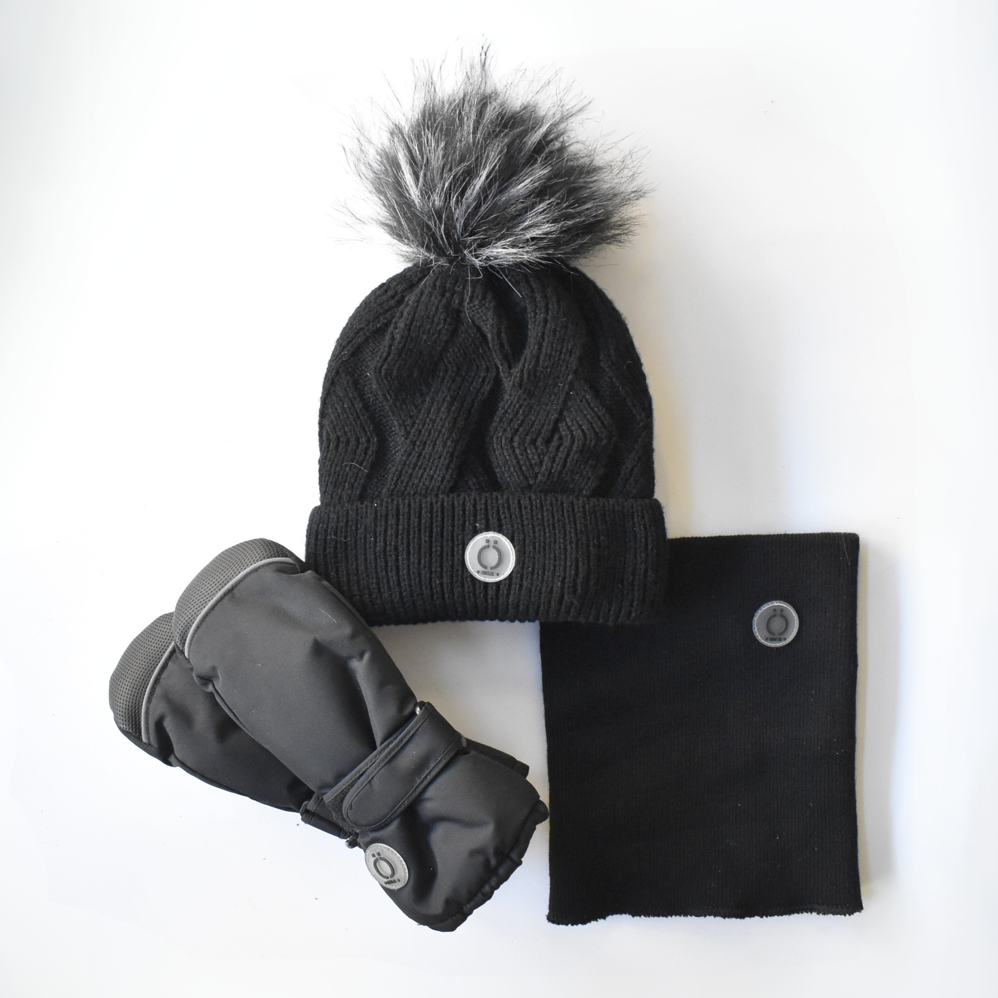 Winter accessory set for kids including a black knit hat with a faux fur pom-pom, matching neck warmer & insulated gloves, all with button detail.