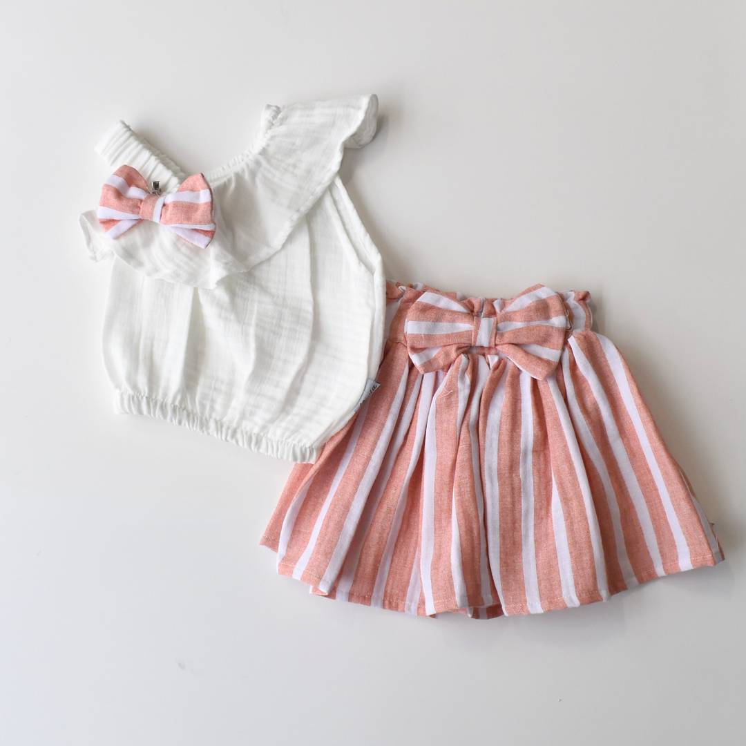 Baby girl outfit set featuring a white sleeveless top with a pink-striped bow and a matching flared skirt with vertical stripes and a bow waistband.