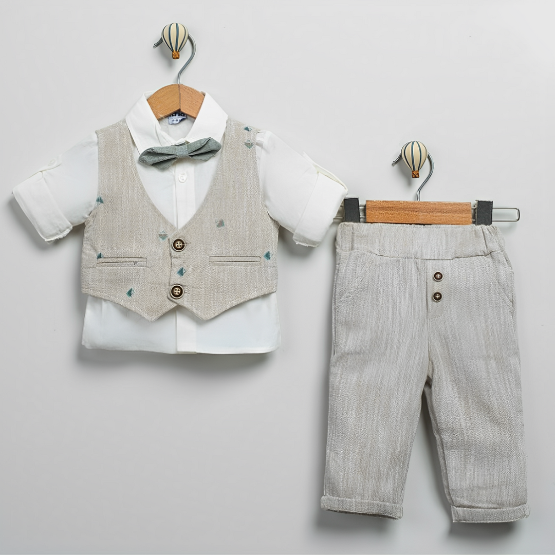 Baby boy outfit with white shirt, beige vest with bow tie, and matching beige pants on hangers.